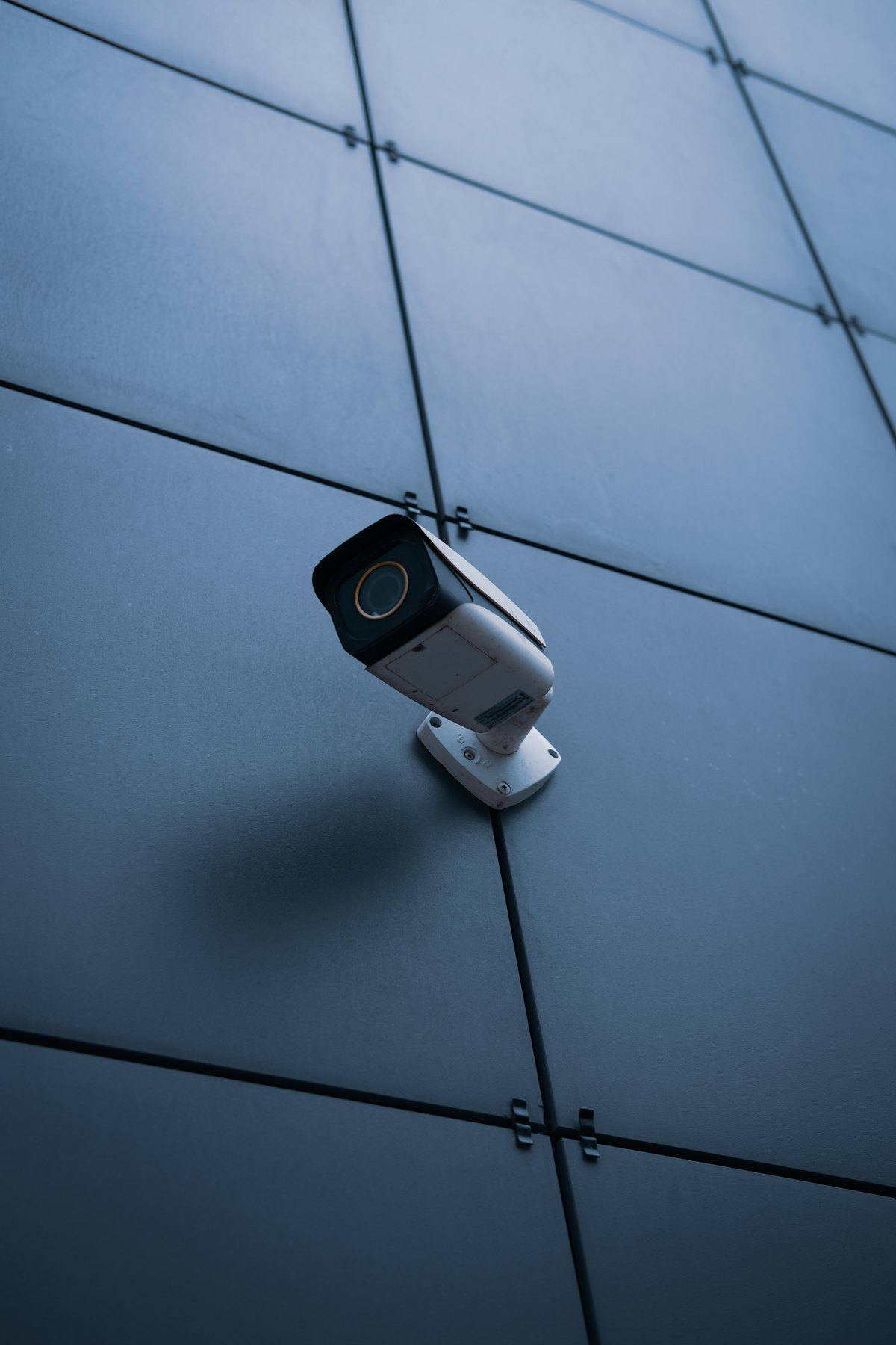 Caméra de vidéosurveillance fixée sur une façade sombre