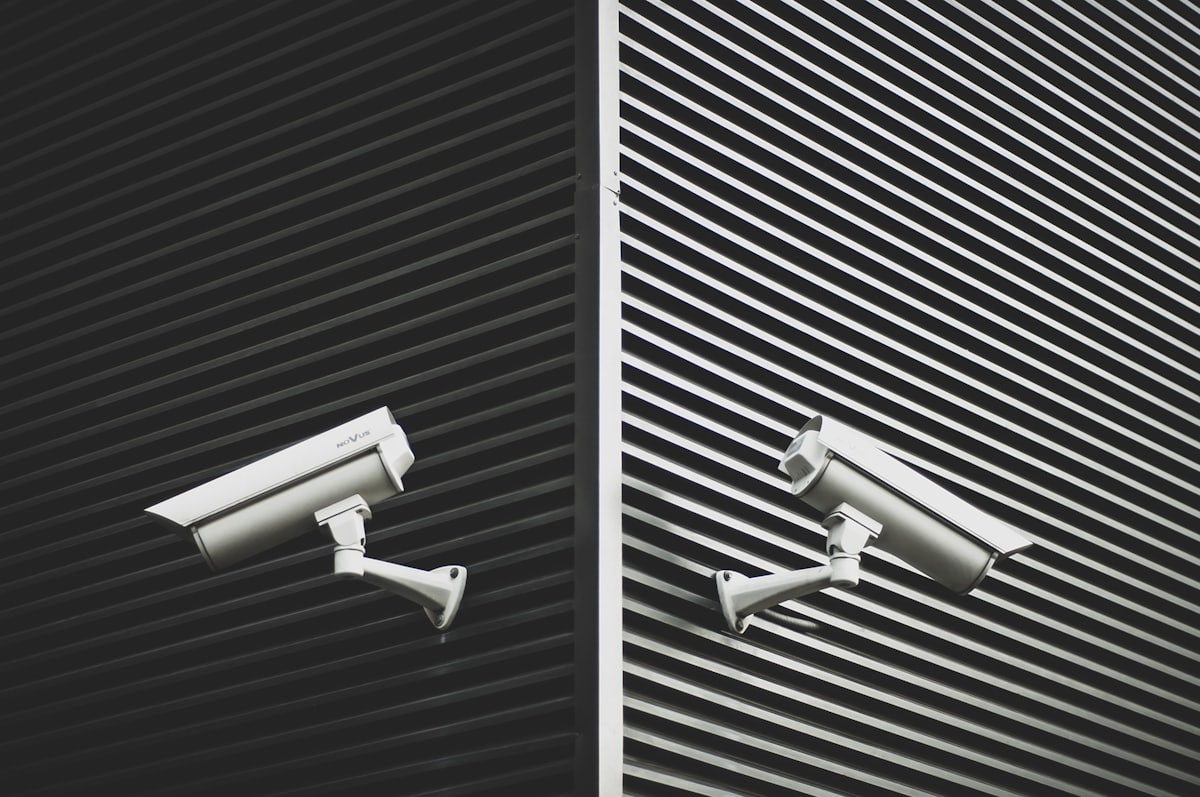 Deux caméras de surveillance montées sur une façade à rayures